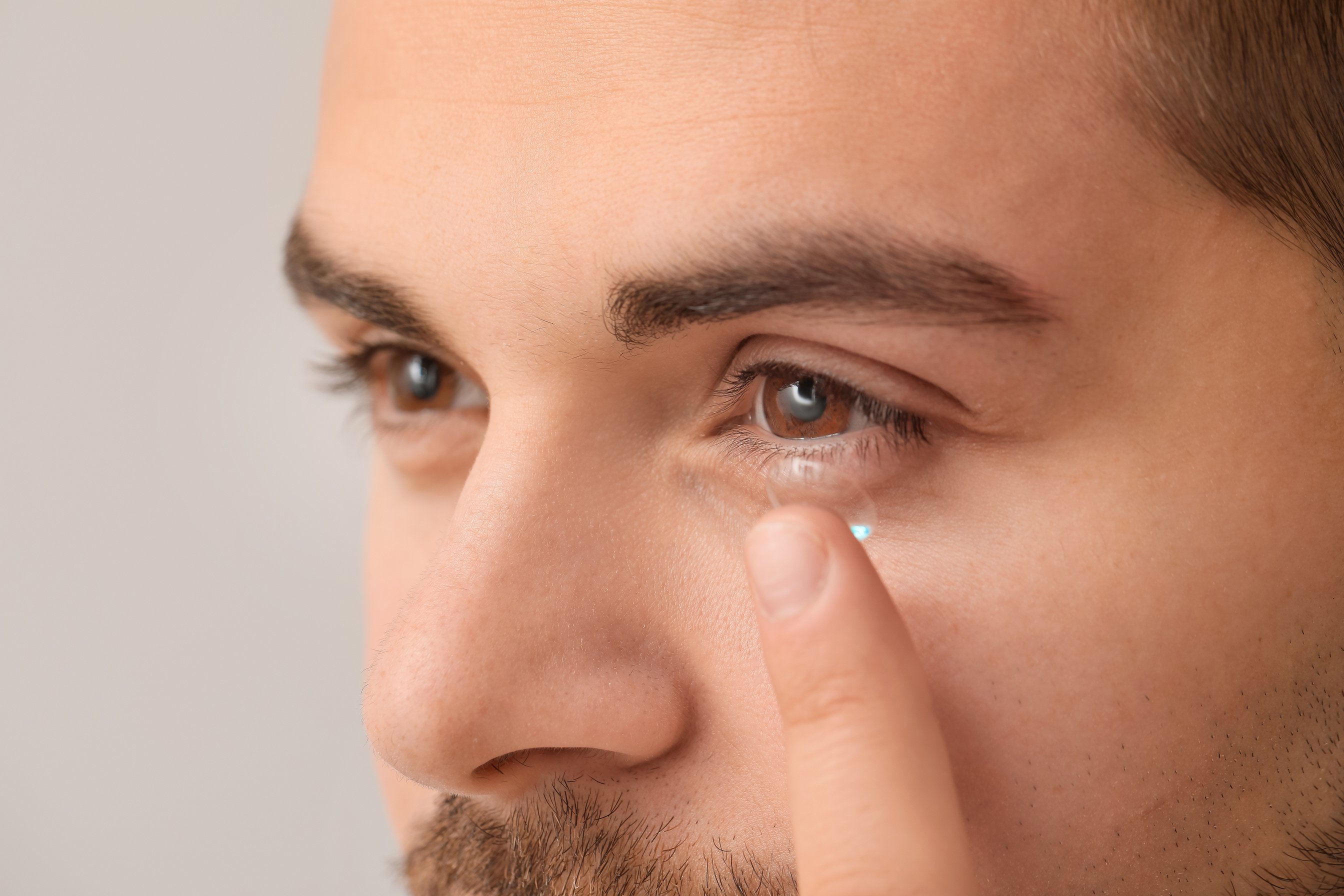 Young Man Putting in Contact Lens